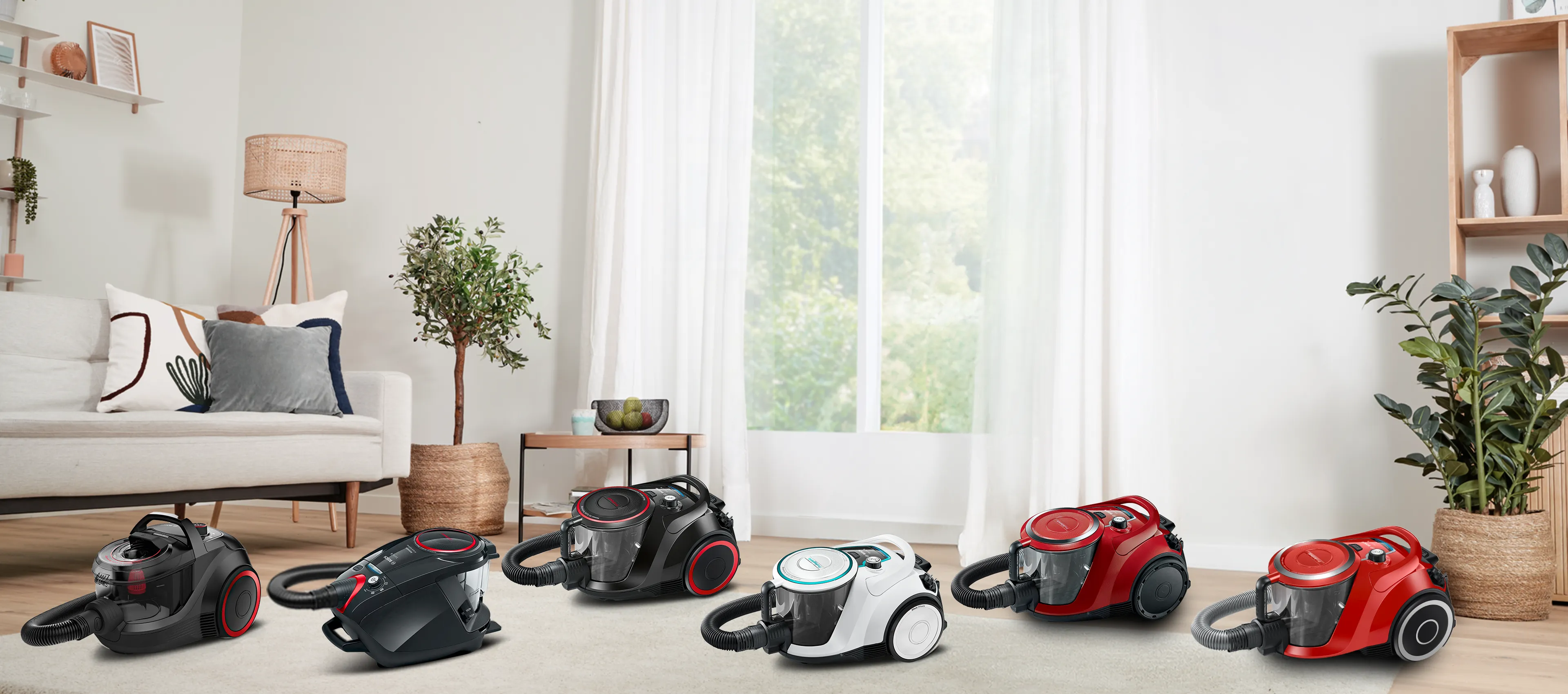 Two Bosch bagless cylinder vacuums stand on a cream rug in a light, bright living room.
