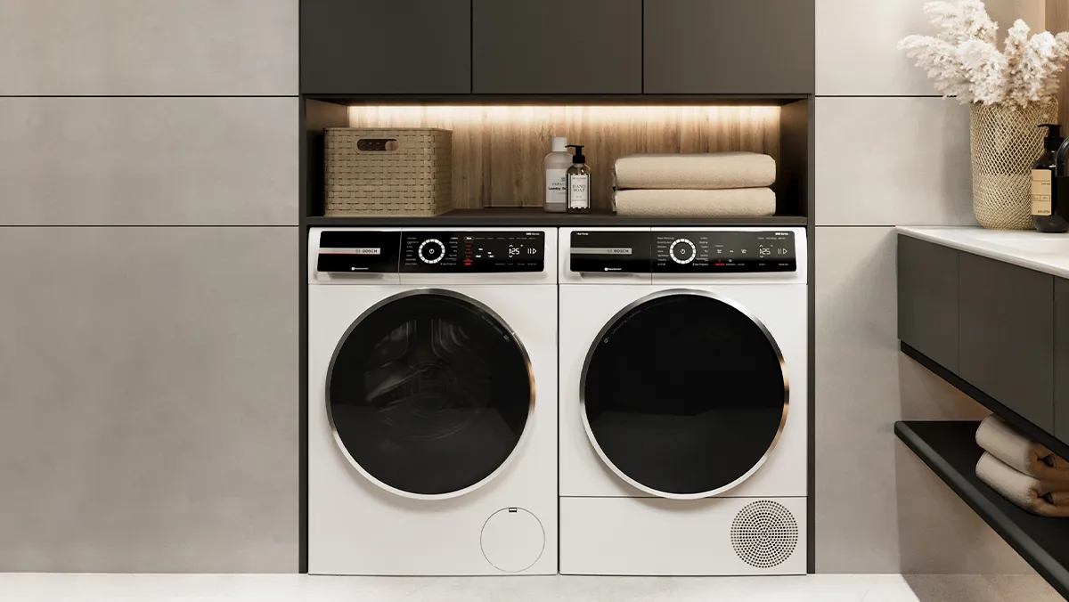 A laundry room featuring a clothing rack with hanging shirts, a pair of white washer and dryer.