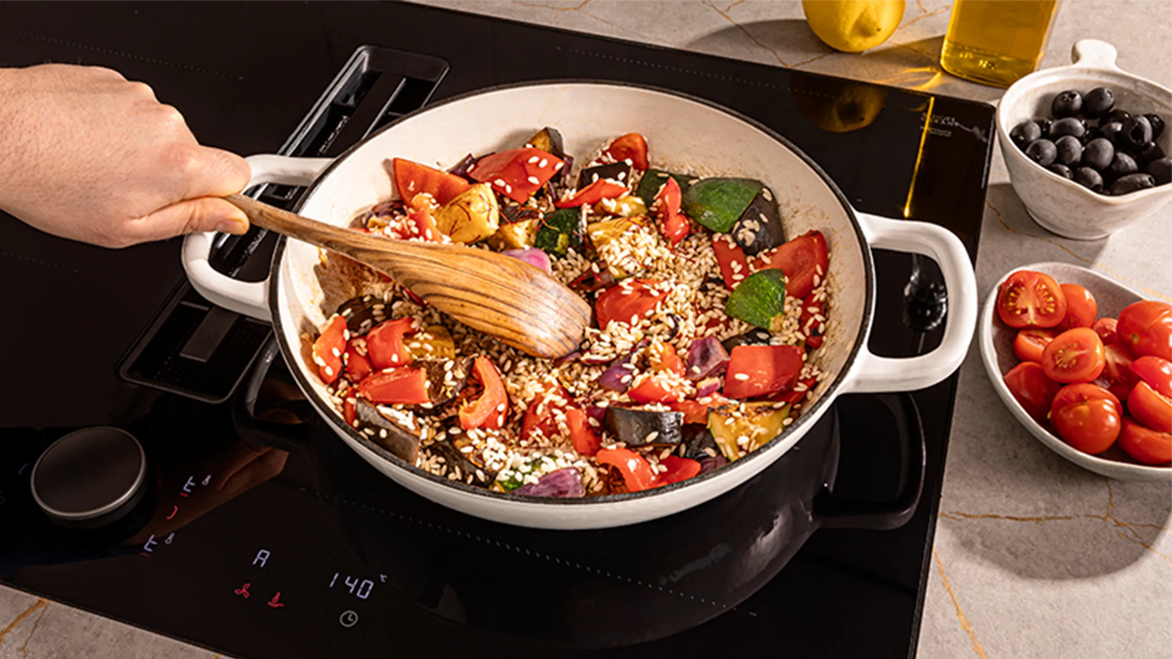 Person cooking colourful veg on a pan over hob