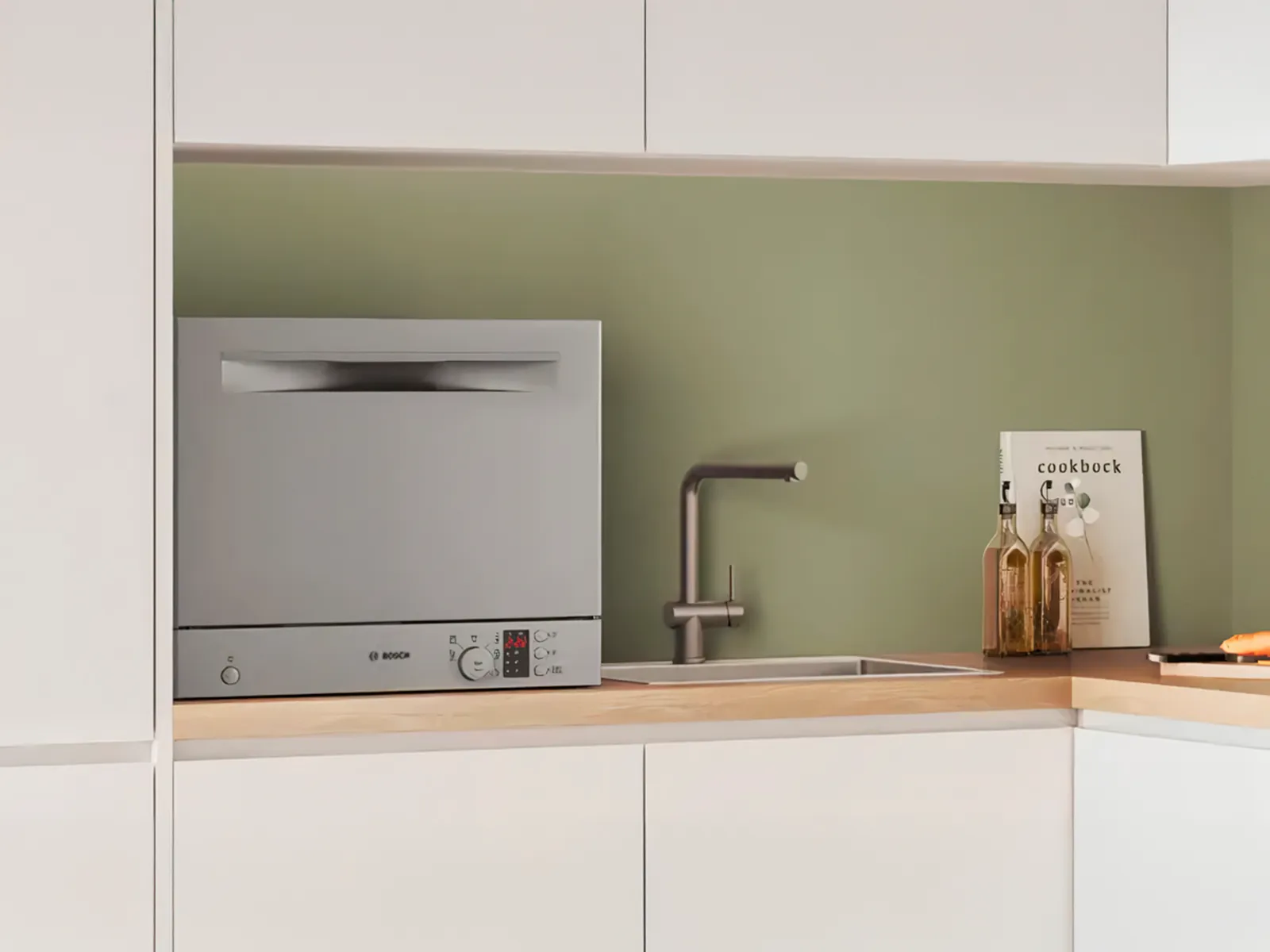 Kompakt diskmaskin placerad på en köksbänk bredvid en diskho, som erbjuder praktisk och effektiv rengöring i små utrymmen.