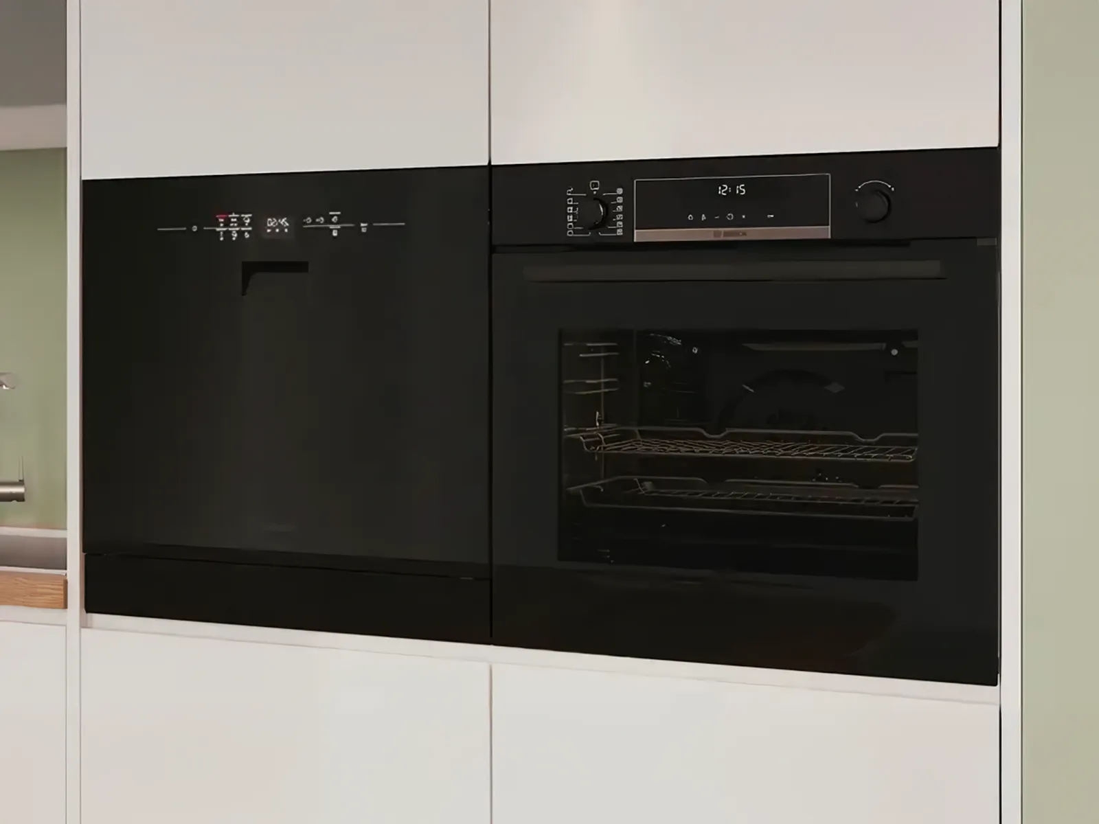 Modernt vitt kök med en svart inbyggd Bosch-diskmaskin och ugn som smälter in sömlöst i skåpluckorna.