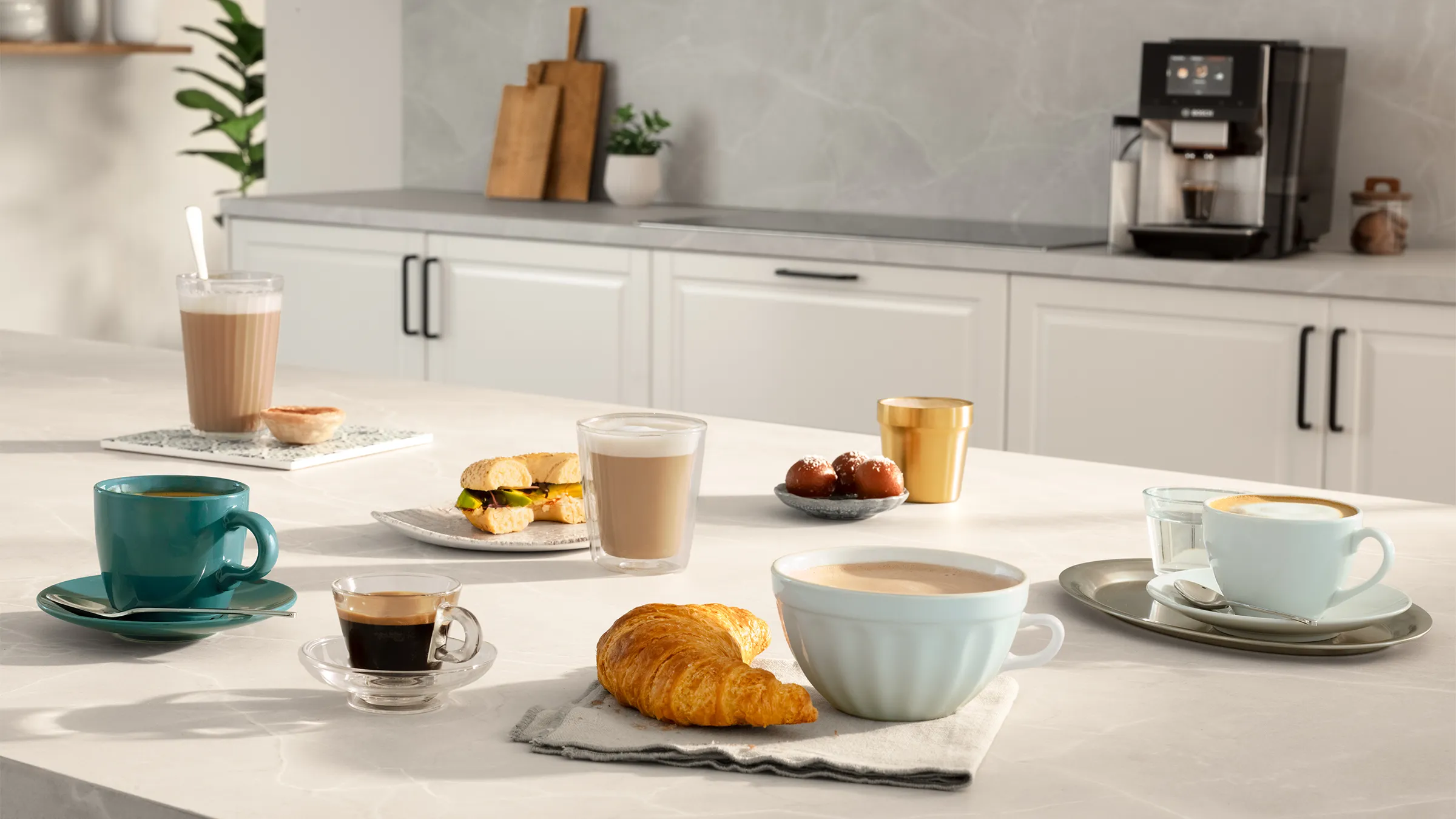 Πλήρως αυτόματη καφετιέρα Bosch VeroCafe Σειρά 8 στον πάγκο της κουζίνας, περιτριγυρισμένη από πολλά ροφήματα καφέ. Ένα δάχτυλο απλώνεται προς την οθόνη αφής.