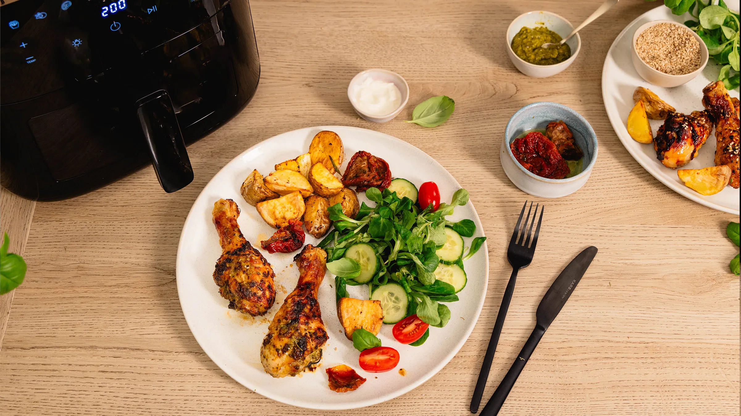 Piatto con cosce di pollo, patate e insalata.
