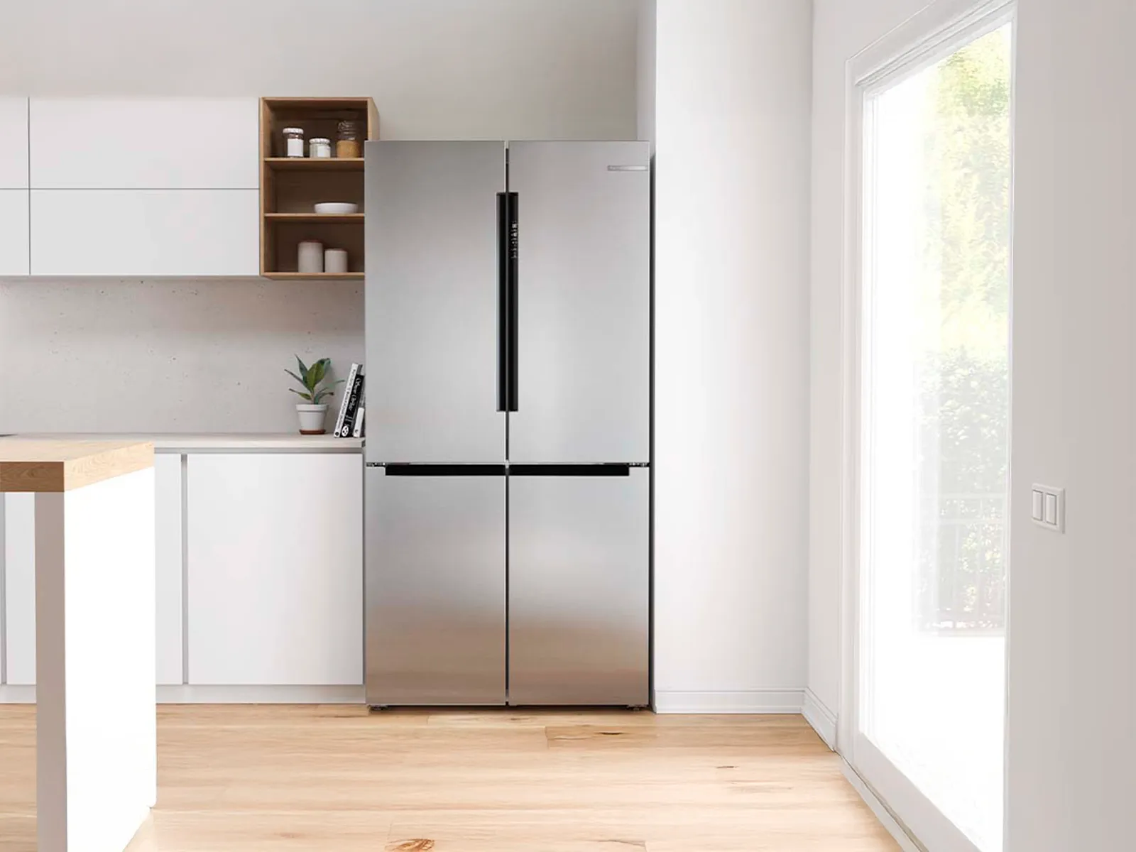 Kyl med franska dörrar med svarta handtag bredvid ett fönster i ett öppet kök.