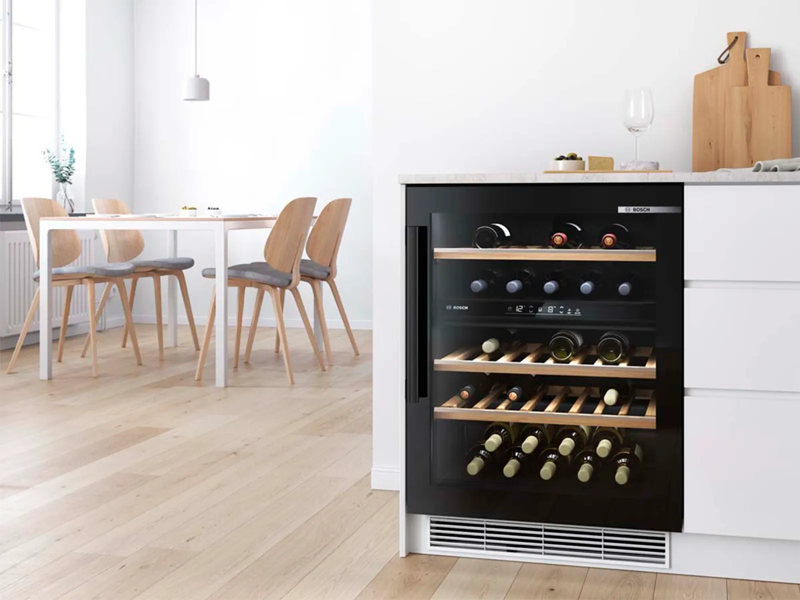 Built-under wine cooler with two temperature zones and a small scandi-style dining room in the background.