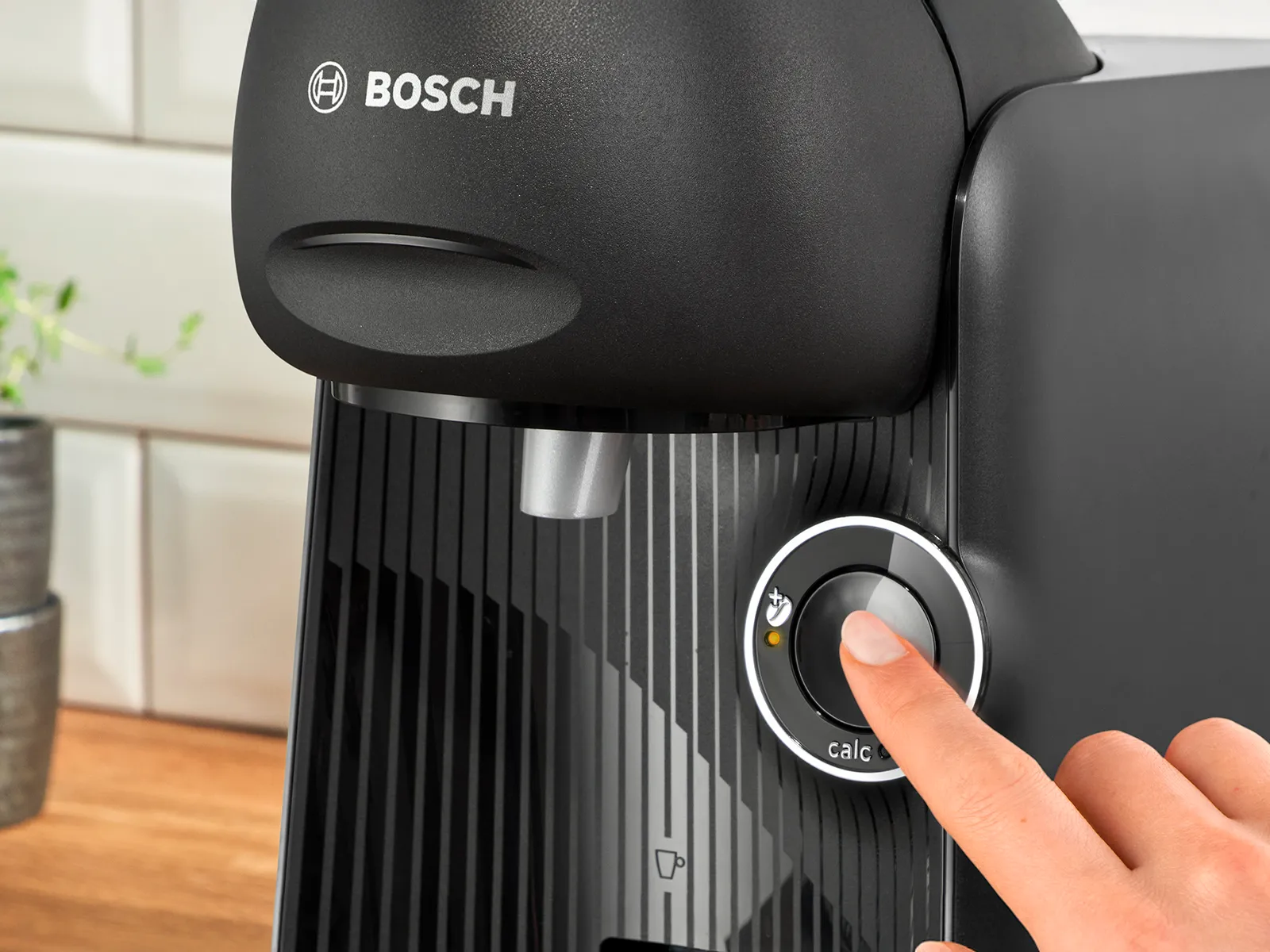 A person clicks on the start button of TASSIMO FINESSE friendly coffee machine.