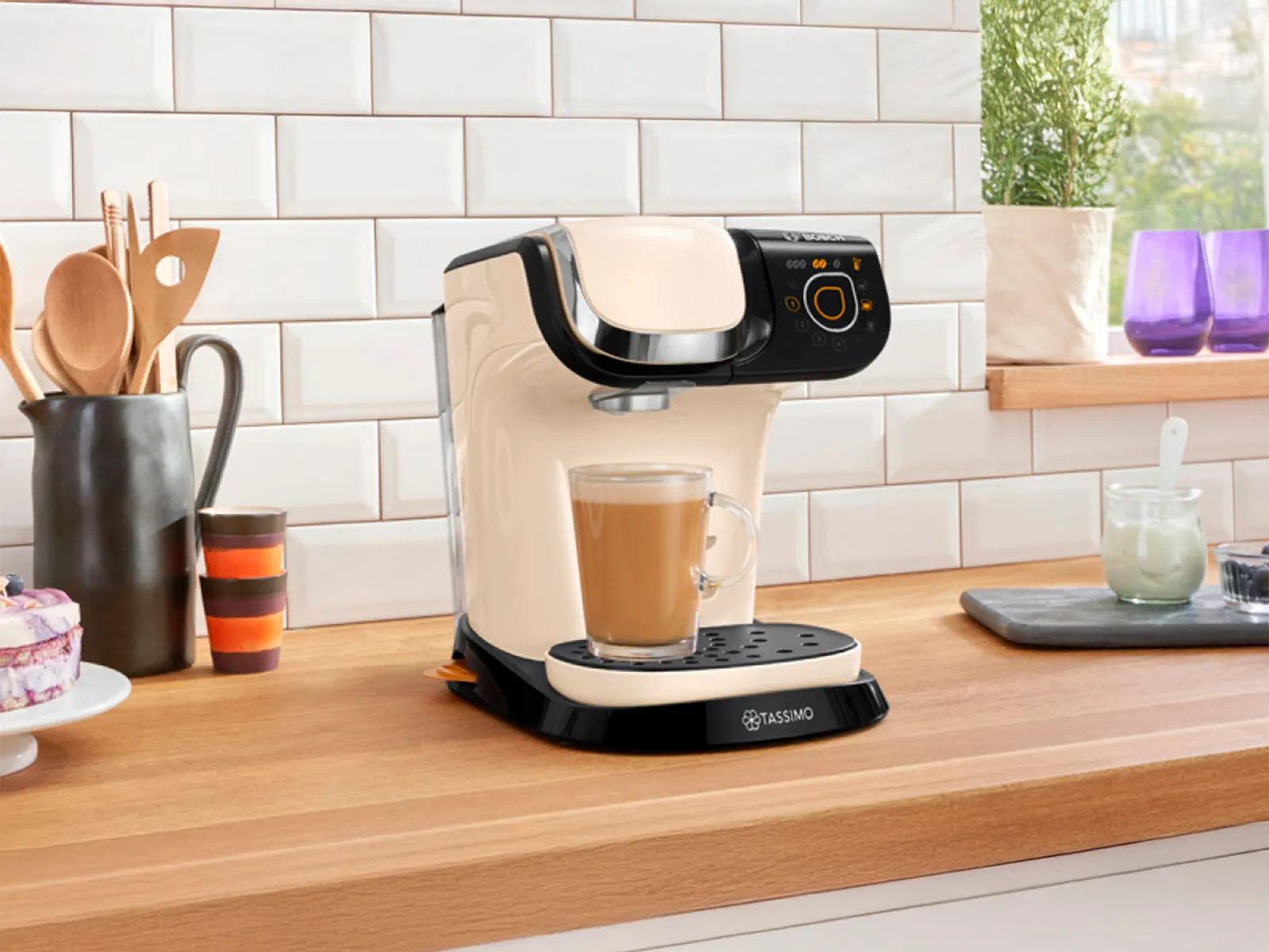 La macchina da caffè TASSIMO MYWAY color beige con un caffè in preparazione sul piano di lavoro della cucina.