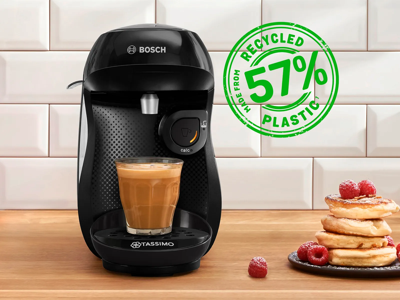 The coffee machine TASSIMO HAPPY friendly on a kitchen worktop with a filled coffee cup.