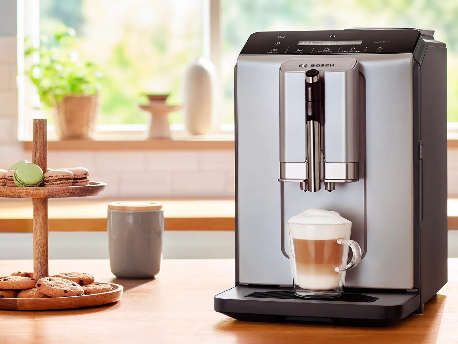 Series 2 VeroCafe coffee machine with cappuccino on kitchen worktop next to biscuit stand.