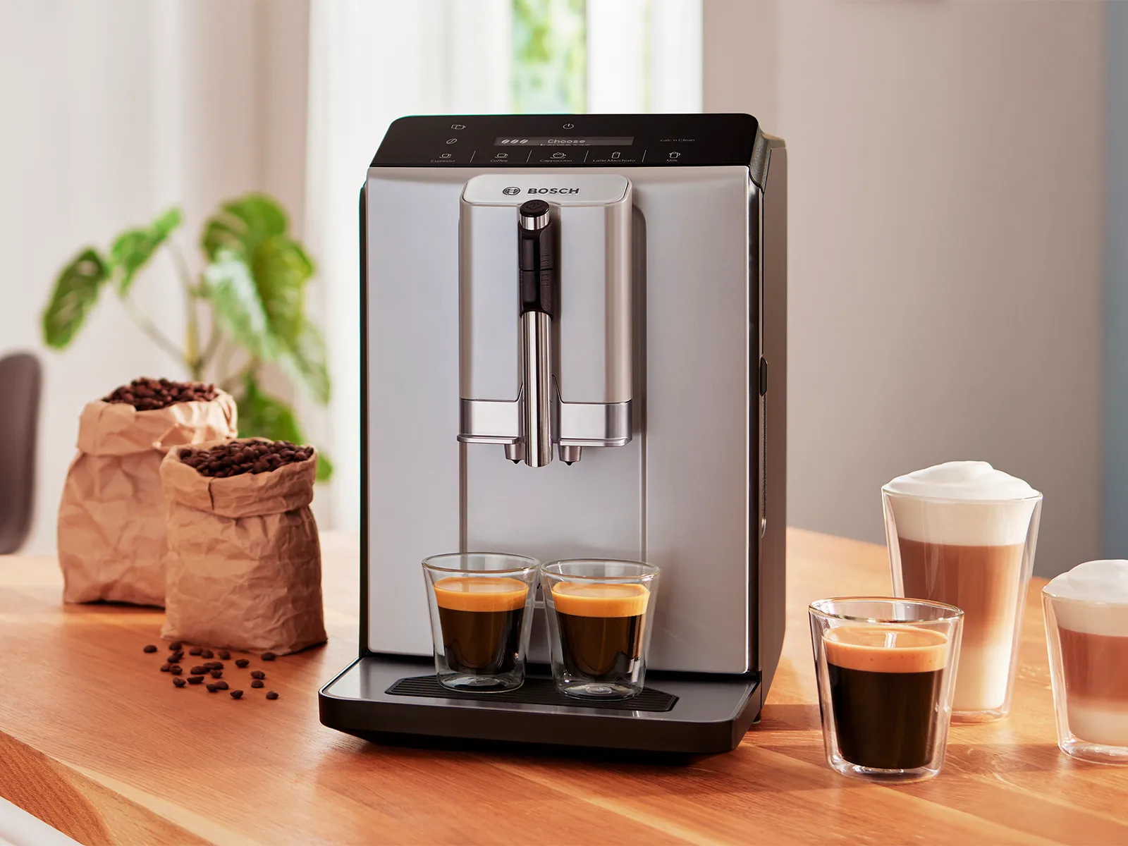 Series 2 VeroCafe coffee machine with 2 cups of espresso on drip tray, plus latte macchiato, coffee and cappuccino on kitchen top.