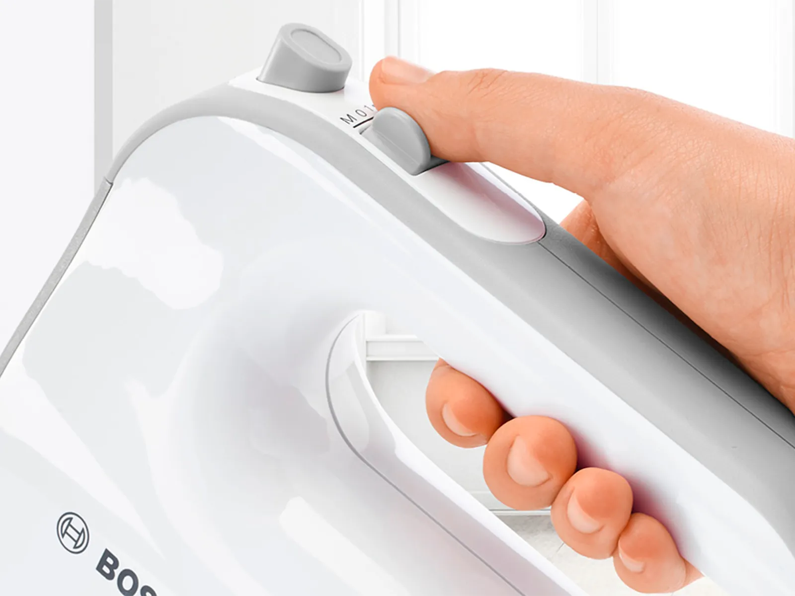 Prikaz blizu ruke koja drži Bosch ručni mikser s SoftTouch premazom za dobar zahvat.