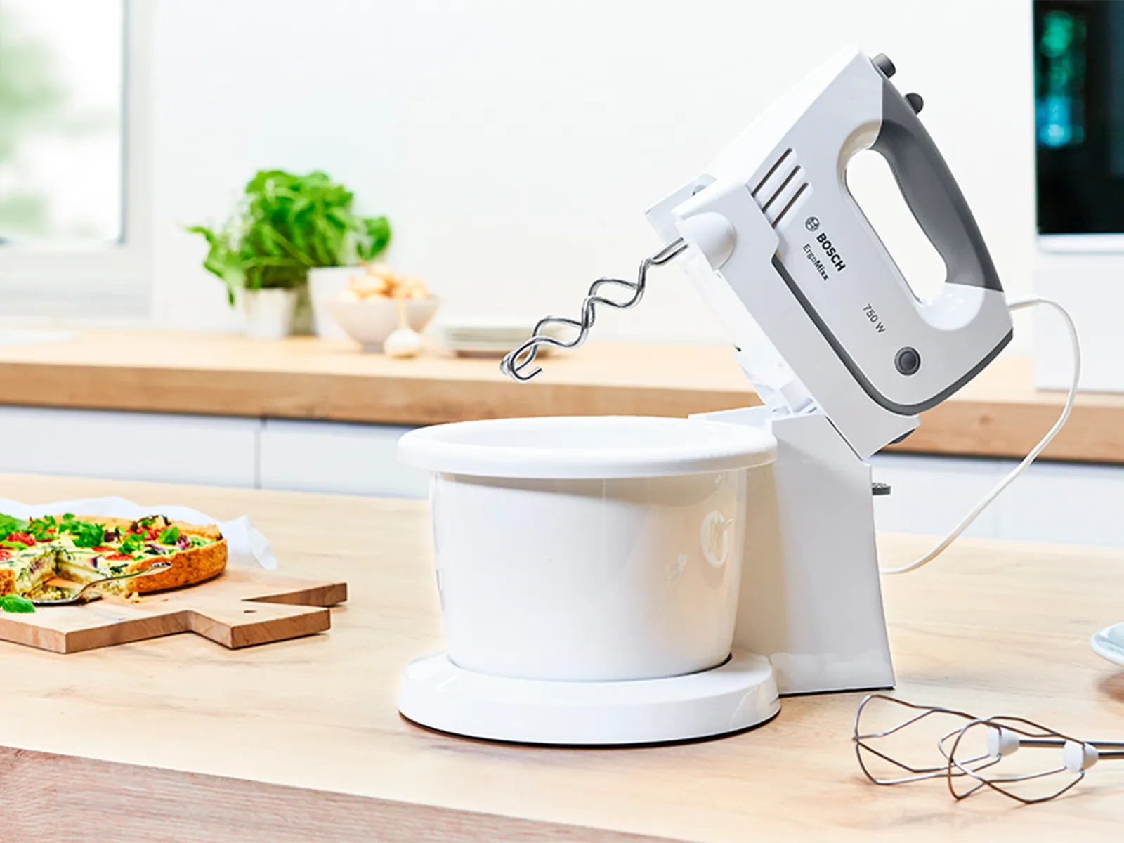 ErgoMixx ručni mikser s posudom za miješanje i postoljem pored quichea.