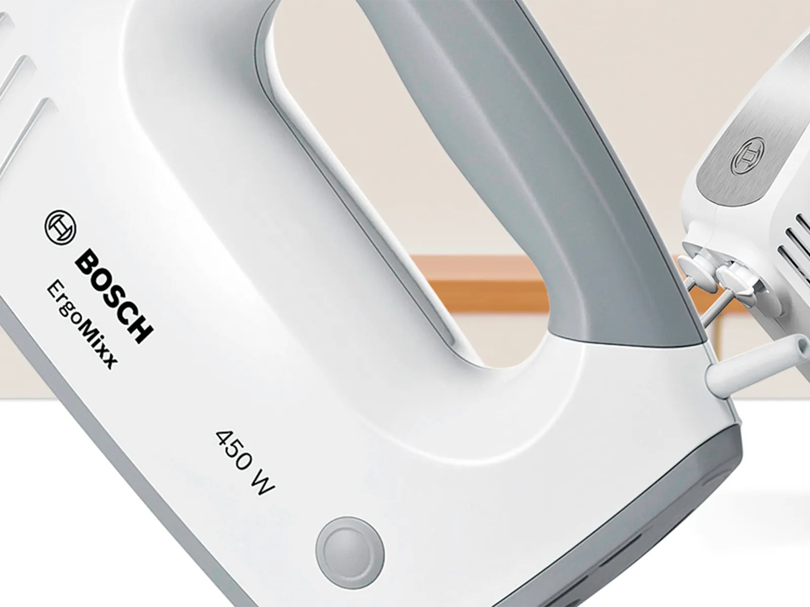 Prikaz blizu ErgoMixx ručnog miksera snage 450 W, dok se iza njega nalazi ručni mikser snage 400 W."