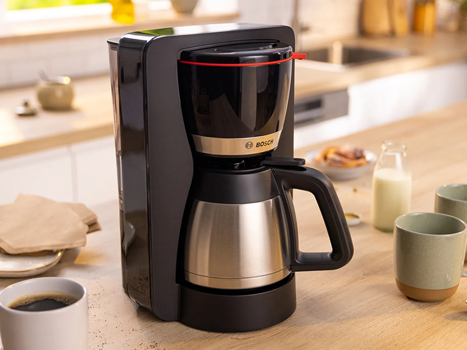 Кафемашина MyMoment на кухненския плот до чаши за кафе.