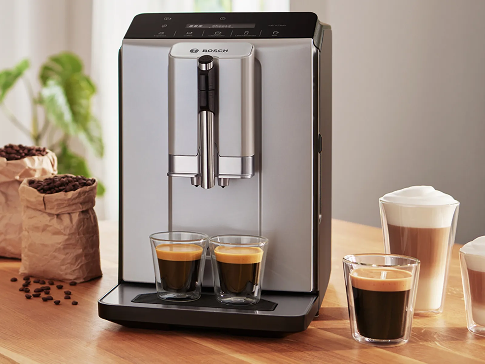 Кафемашина VeroCafe от Серия 2 с 2 чаши еспресо на поднос за капки, плюс лате макиато, кафе и капучино на кухненския плот.