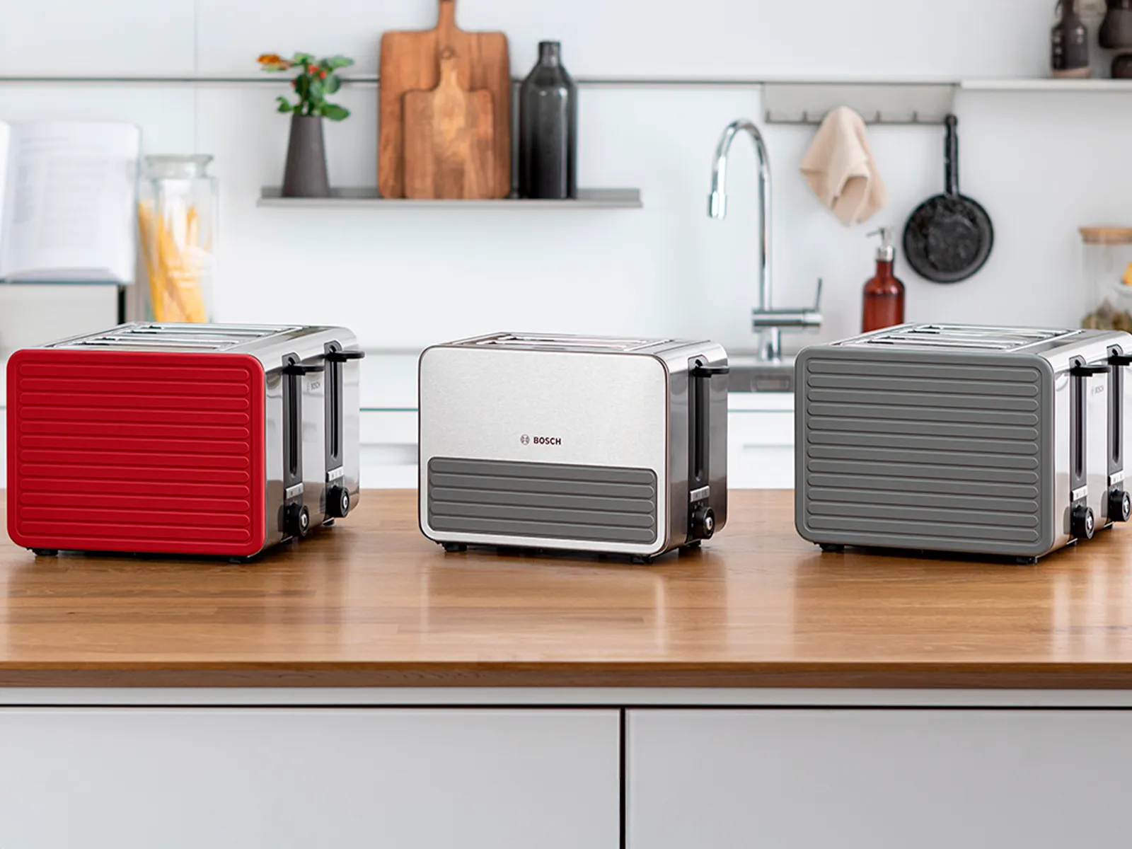 Силиконови тостери на кухненския плот: 4 филийки в червено, 2 филийки компактен в сиво и 4 филийки в сиво.