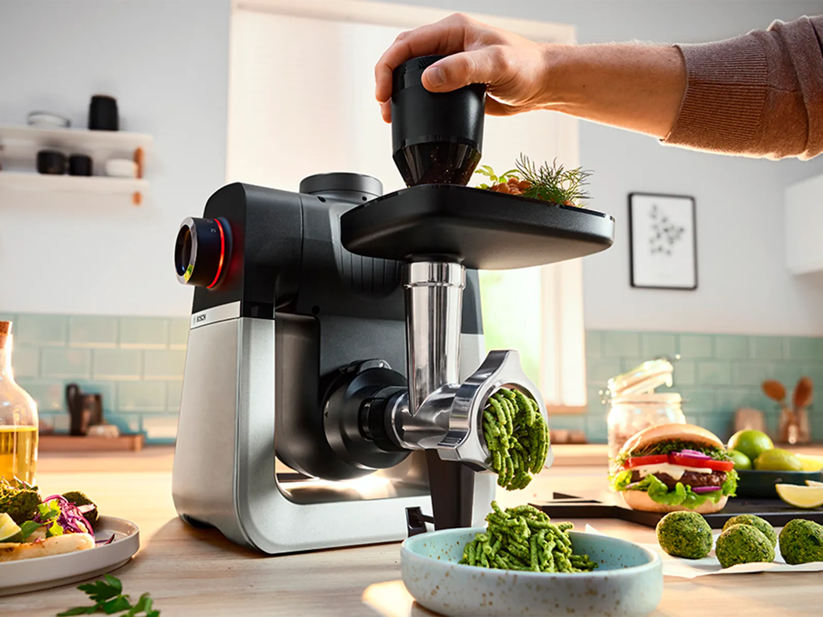 Un bărbat utilizează un împingător pentru a procesa legume într-o maşină de tocat MultiPower din Seria 4.