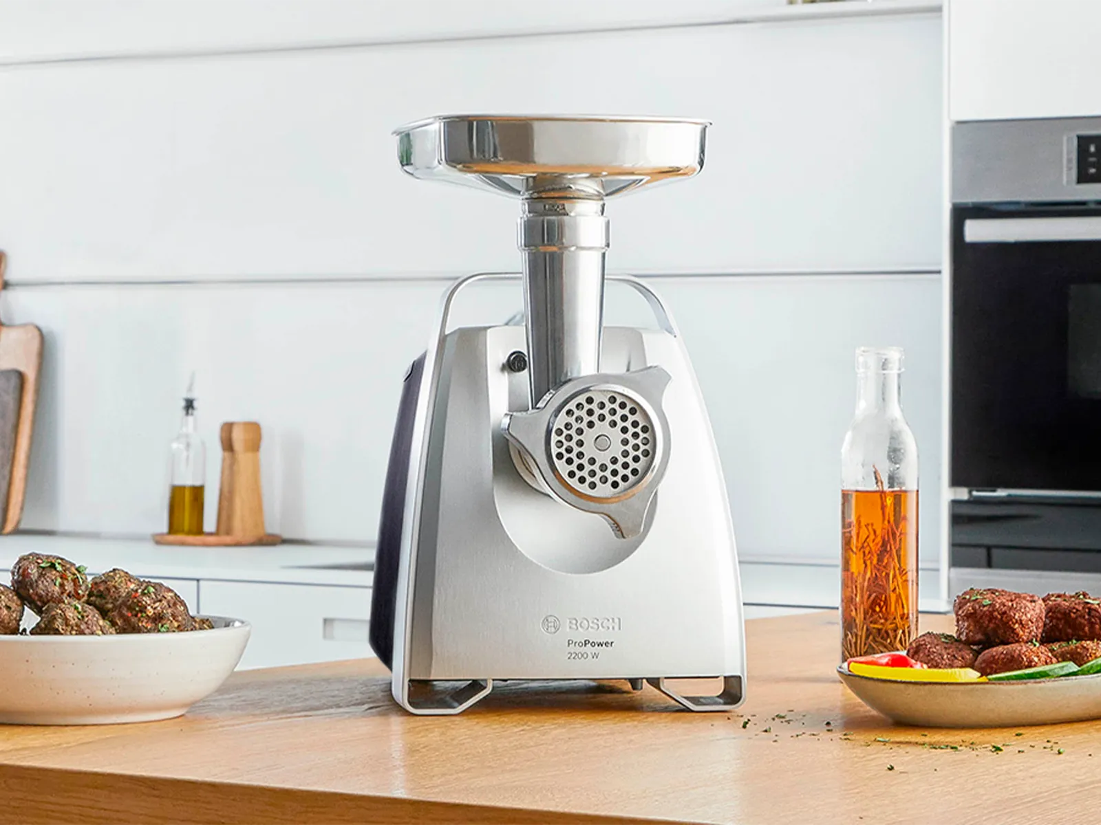 Tocătorul de carne ProPower pe un blat de bucătărie lângă o farfurie cu Kibbeh şi cu legume.