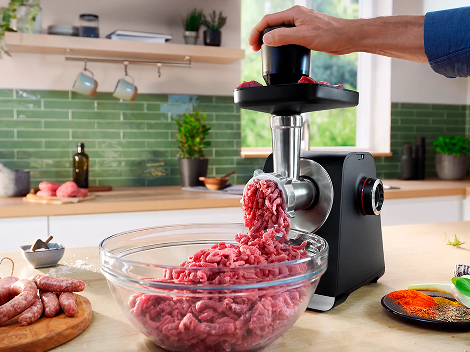 MultiPower din Seria 4 cu carne în tava superioară, lângă farfurii cu Kibbeh, cârnaţi şi salată.