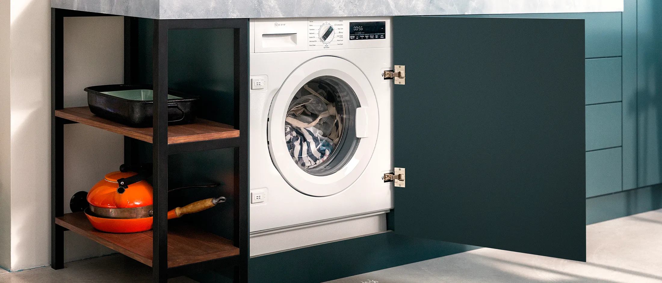 Waschmaschine im offenen Küchenschrank unter der Arbeitsplatte.