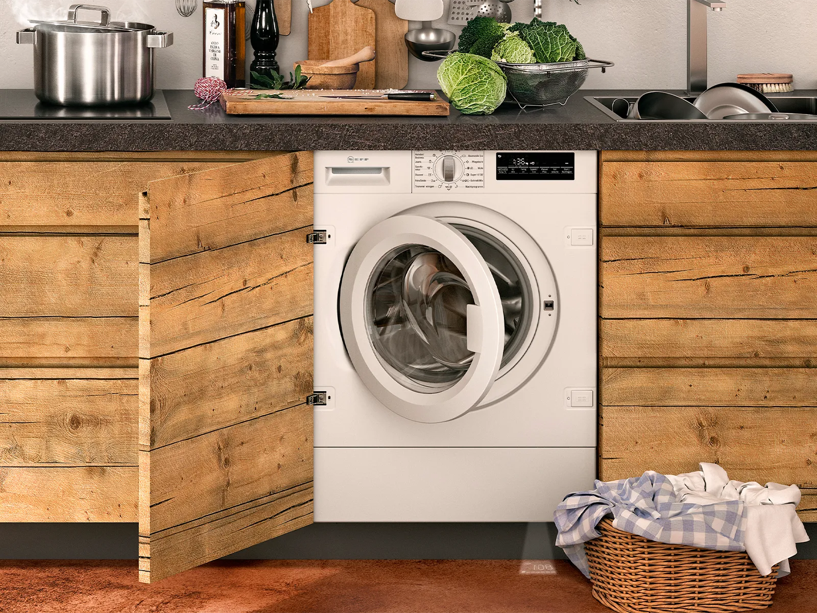 An open washer dryer with a wash basin of cloth to the right of it
