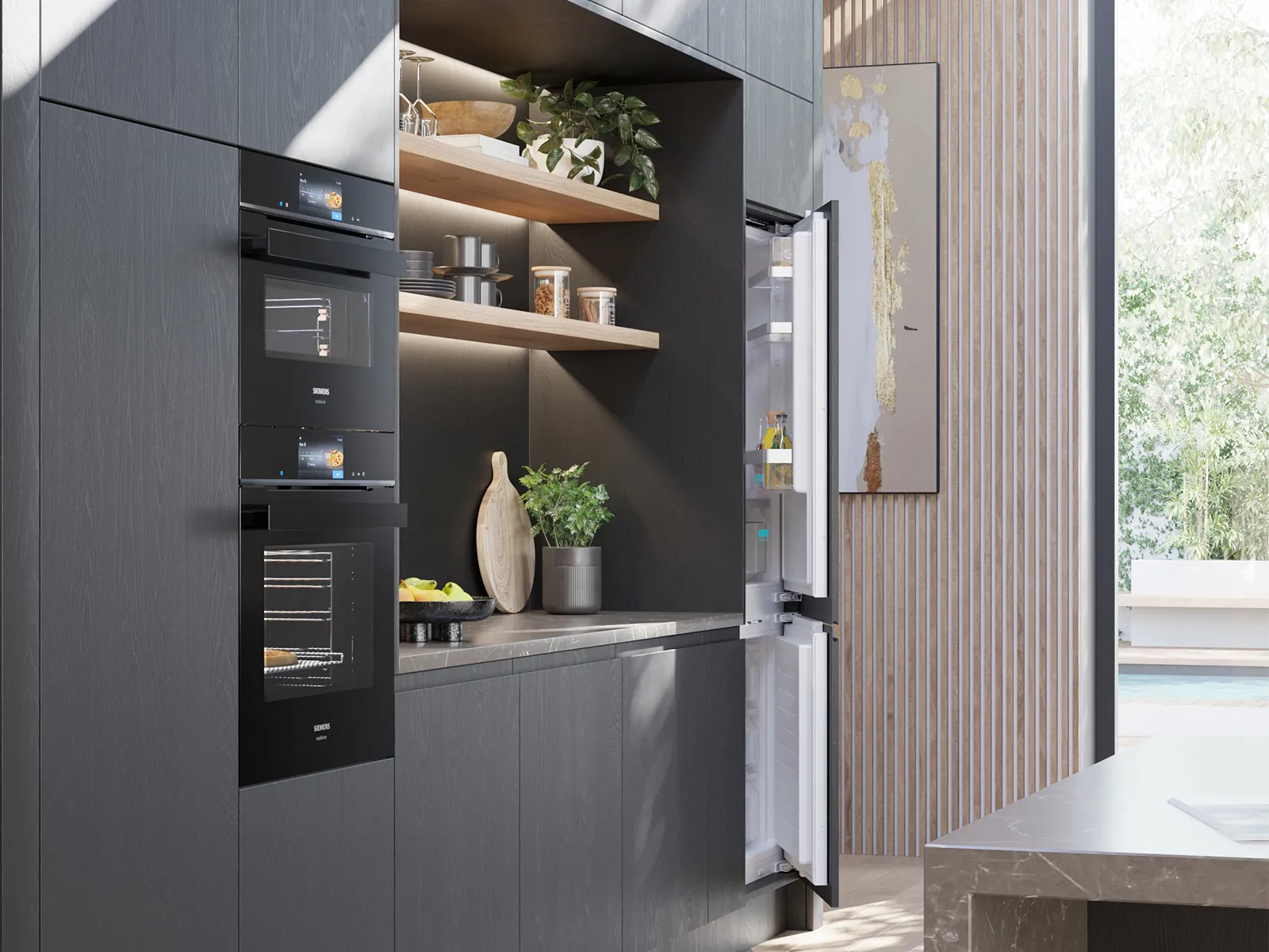 מטבח מודרני ואלגנטי עם שני תנורי סימנס מובנים זה על גבי זה.