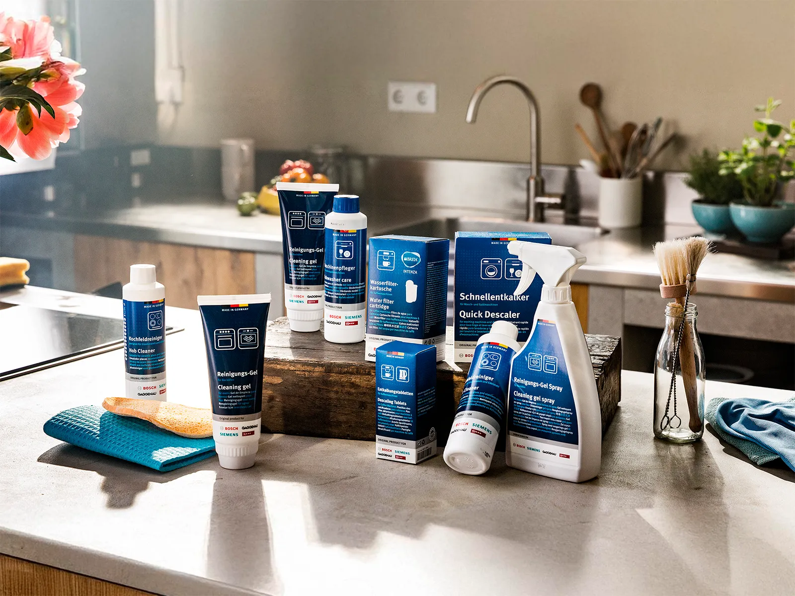 NEFF cleaning and care accessories, including descalers and cleaning gels, displayed in a modern kitchen.