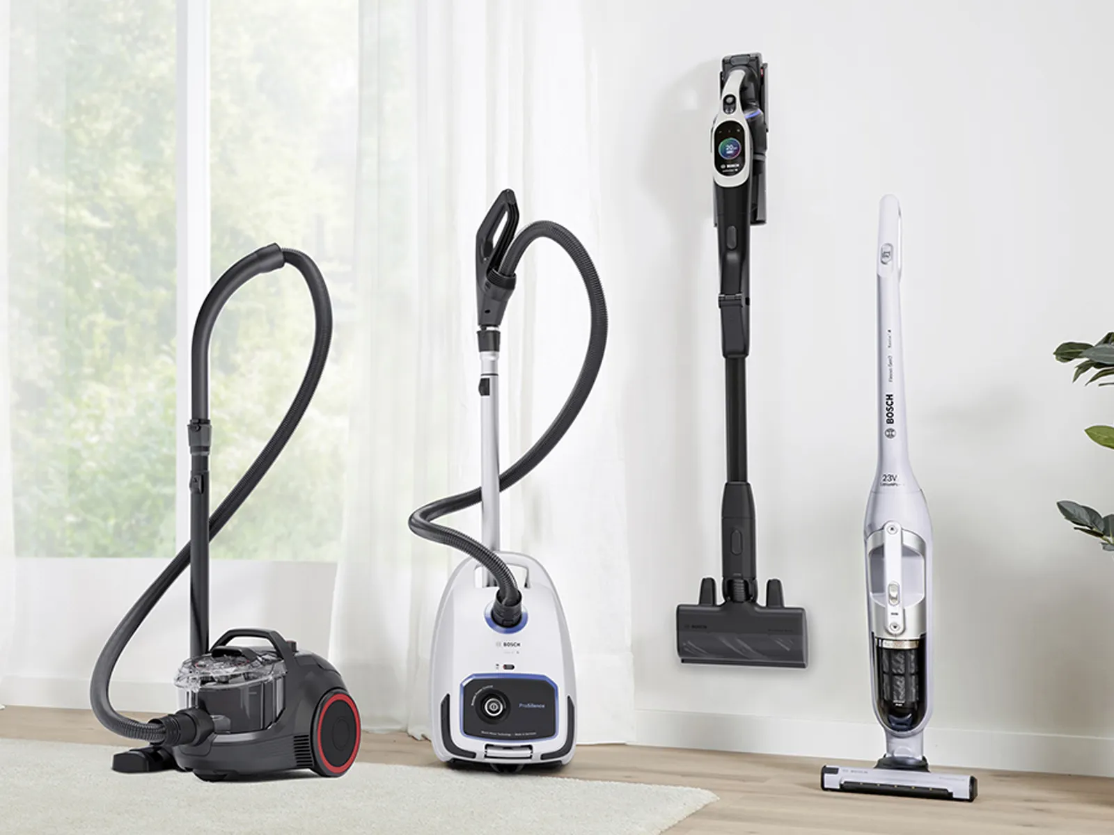 Three different types of vacuum cleaners displayed in a bright room.