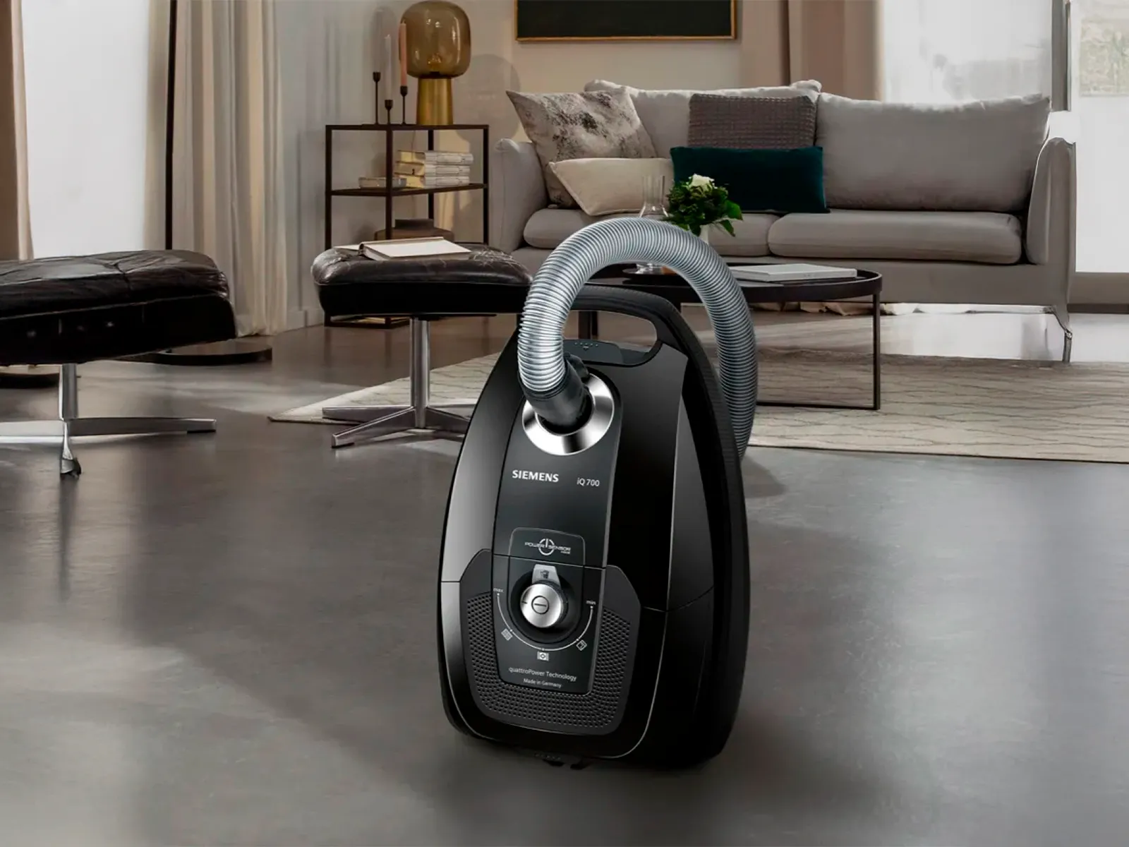 A black Siemens vacuum cleaner on a modern living room floor.