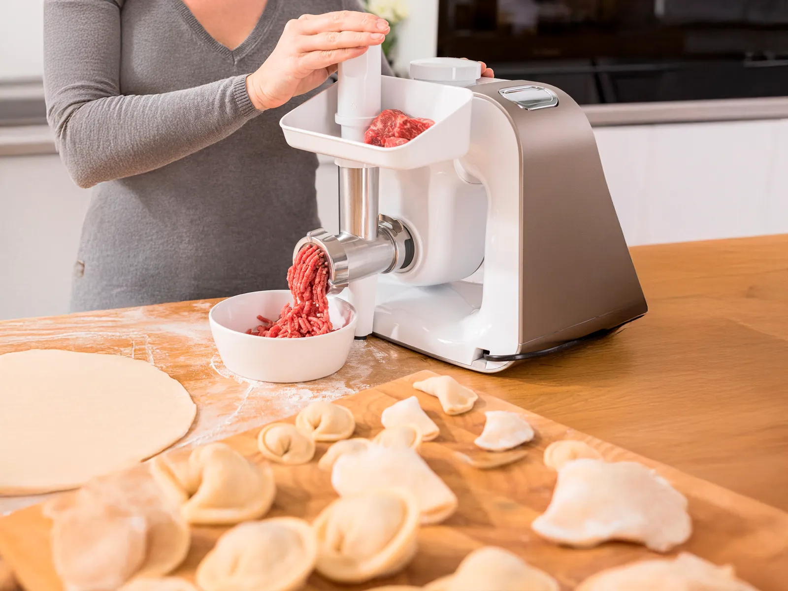 Accessoire hachoir à viande du robot pâtissier Bosch Série 4 en train de hacher de la viande.