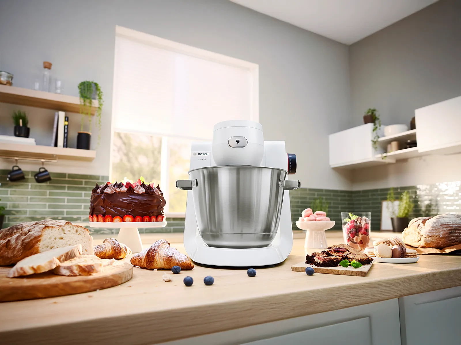 White version Series 6 stand mixer on kitchen counter surrounded by fruit and other food items.