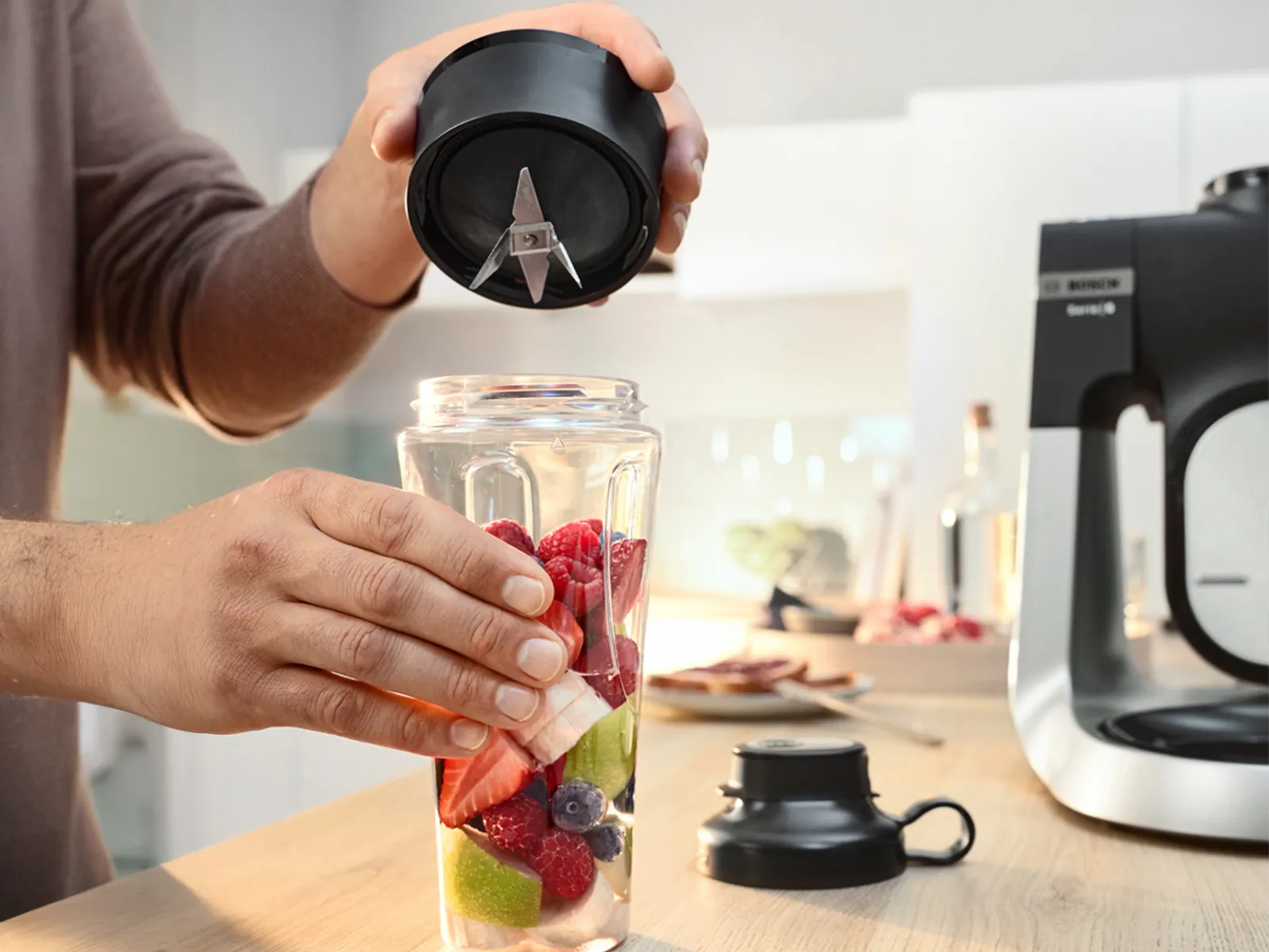 ToGo bottle filled with sliced fruit, next to lid and Series 6 stand mixer on the kitchen counter