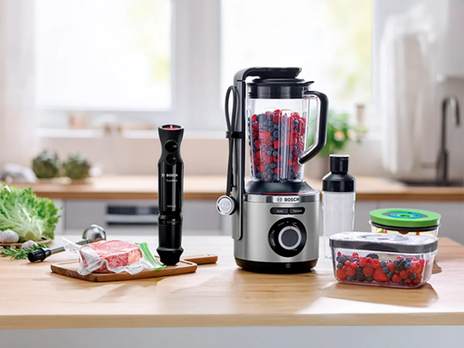 Bosch vacuum-sealing hand blender and blender on a kitchen worktop next to compatible containers.