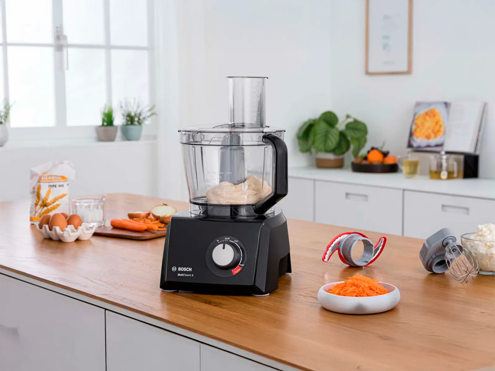 Boschin monitoimikone erilaisten keittiön työtasolla. Vieressä erilaisia ruokia.