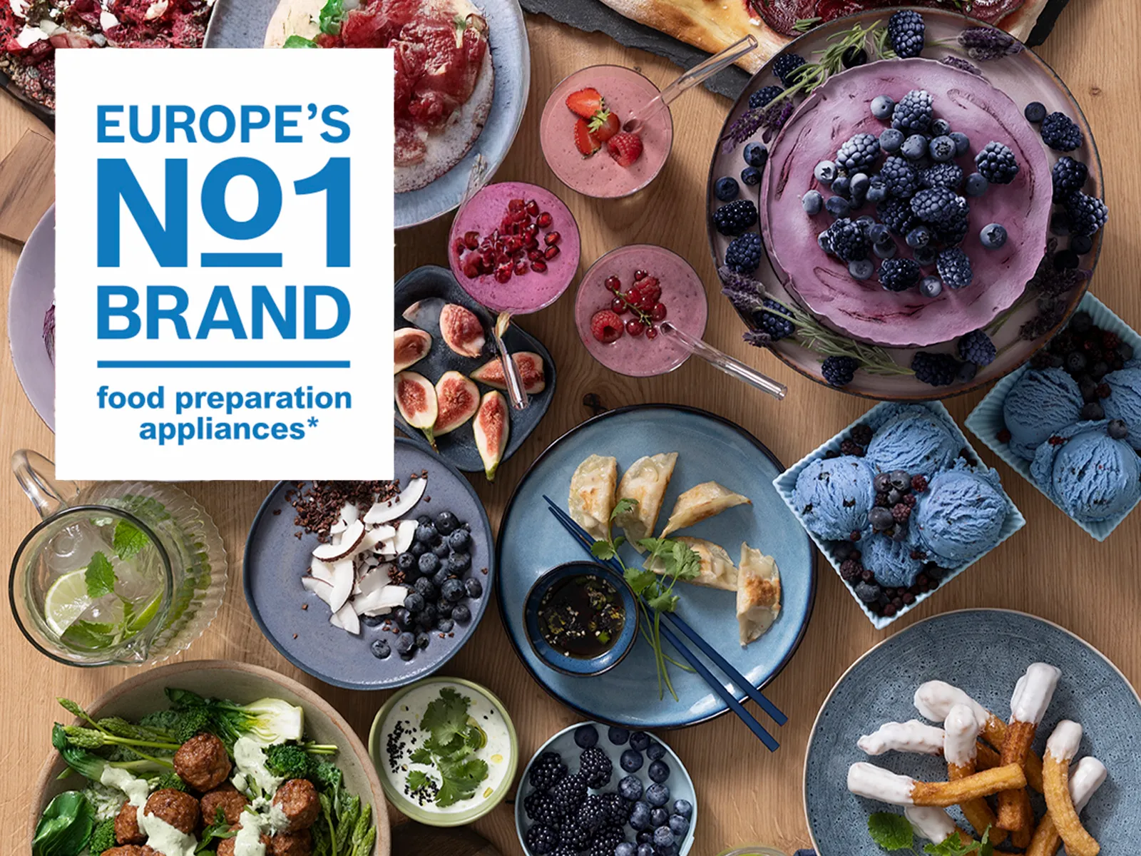 Europas Nr. 1 Marke für Küchengeräte zur Lebensmittelzubereitung, präsentiert über einem Tisch voller lebendiger Gerichte, Desserts und Getränke.