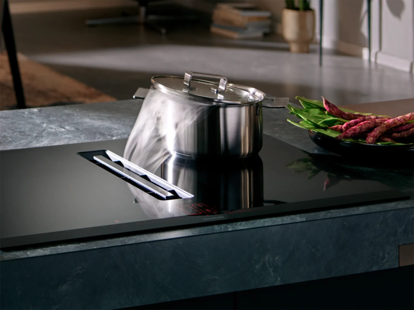 Siemens induktionshäll med integrerad ventilation som fångar ånga från en kokande kastrull.