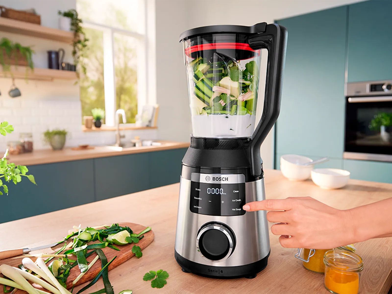 Ruka osobe interagira s kontrolnom pločom visokoučinkovitog blendara i miješa zelene sastojke.