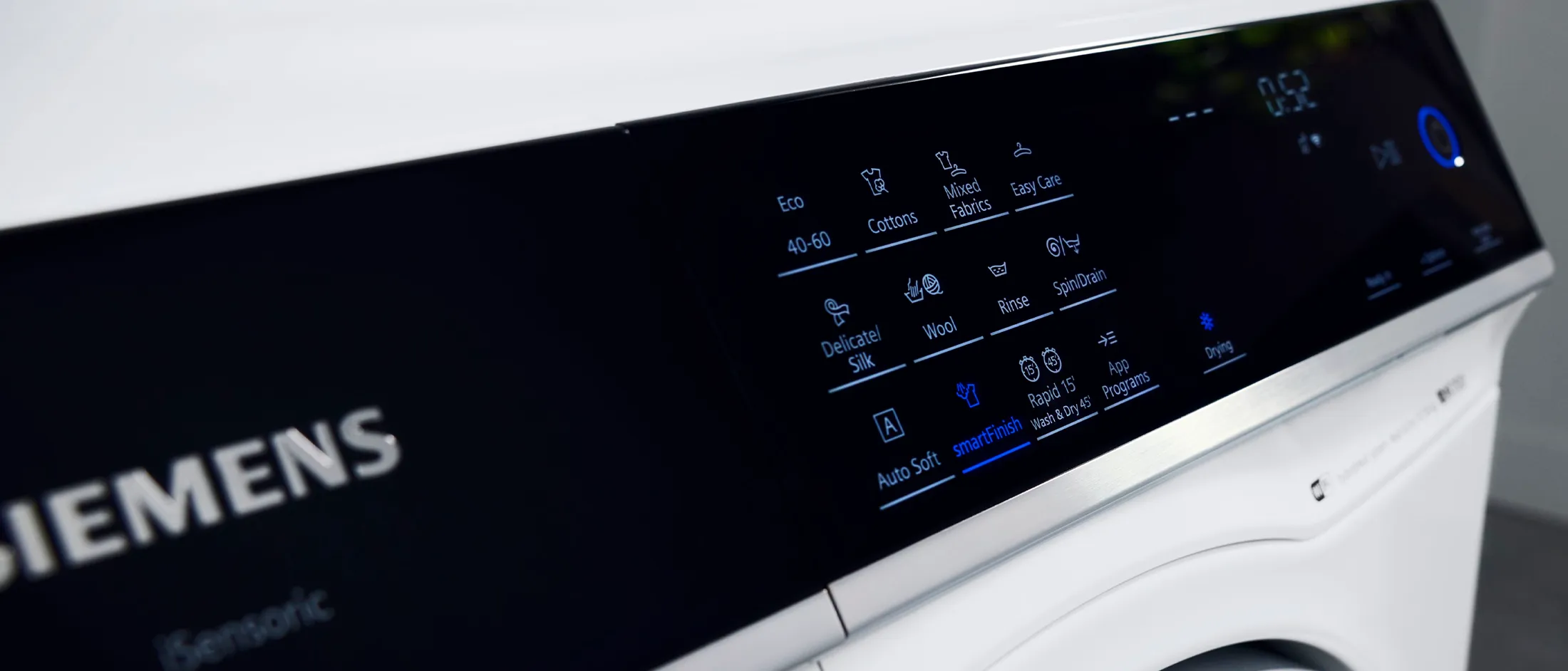 Close-up of a modern Siemens washing machine control panel with illuminated settings.