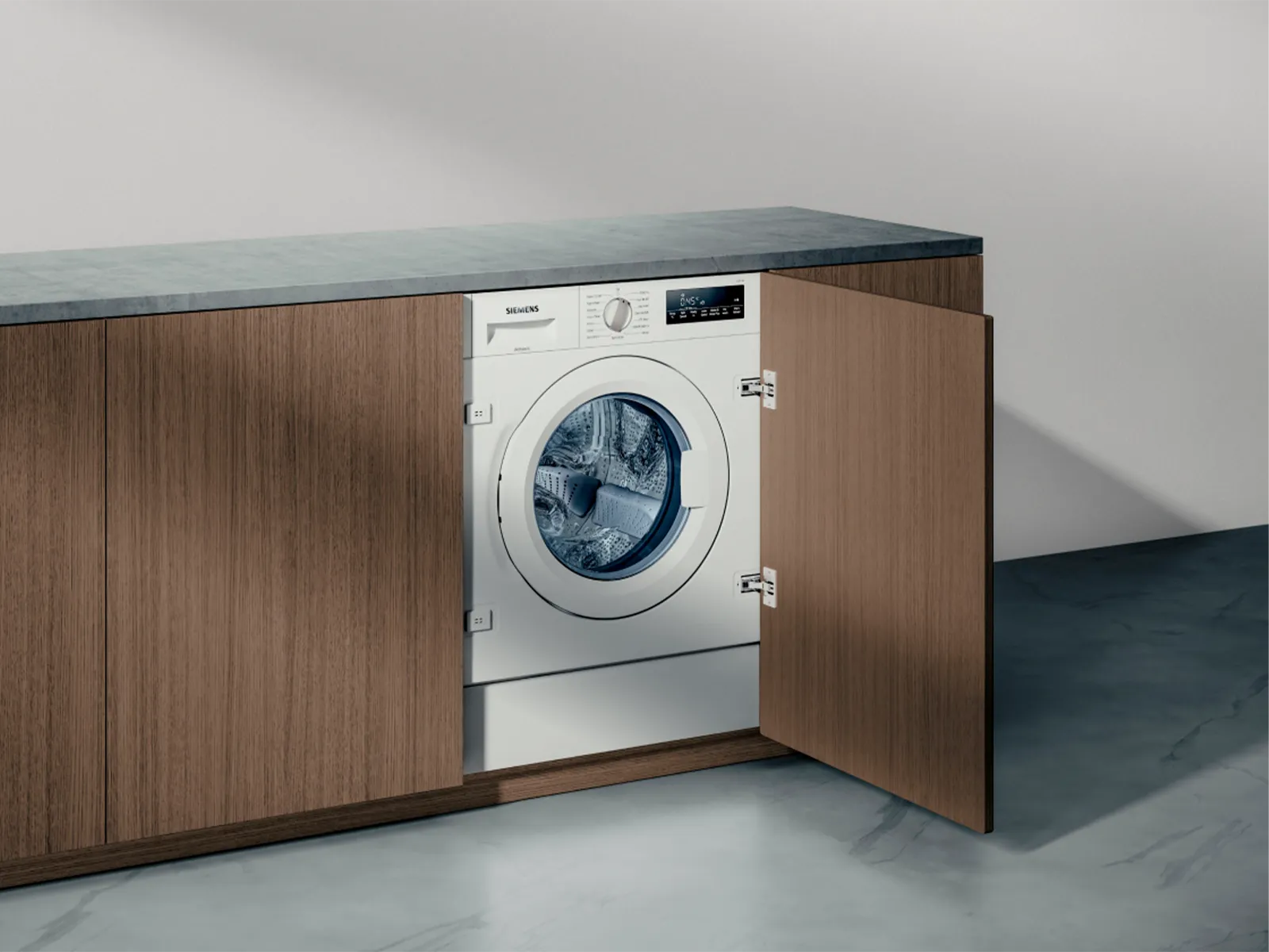 Indbygget vaskemaskine i et moderne køkkenskab med træfinish.
