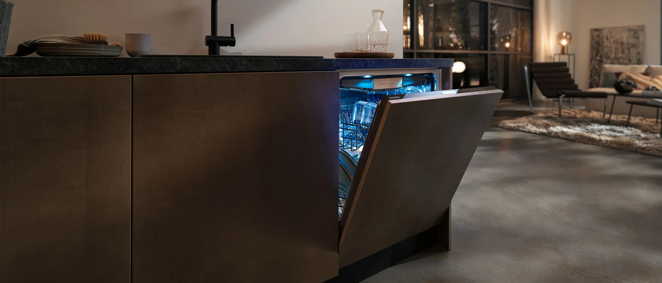 A modern kitchen featuring a sleek, partially open dishwasher with blue interior lighting, set against a stylish living space.