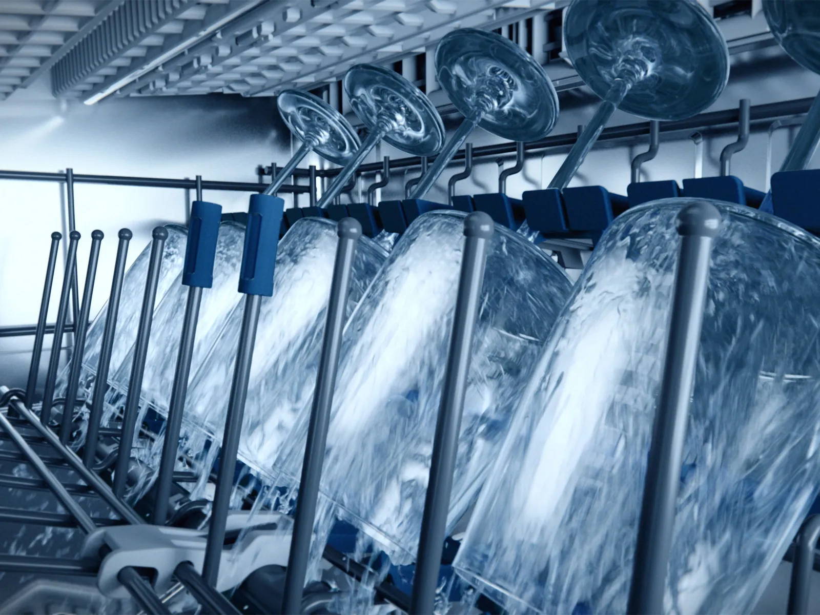 Dishwasher interior with plates and glasses being washed.