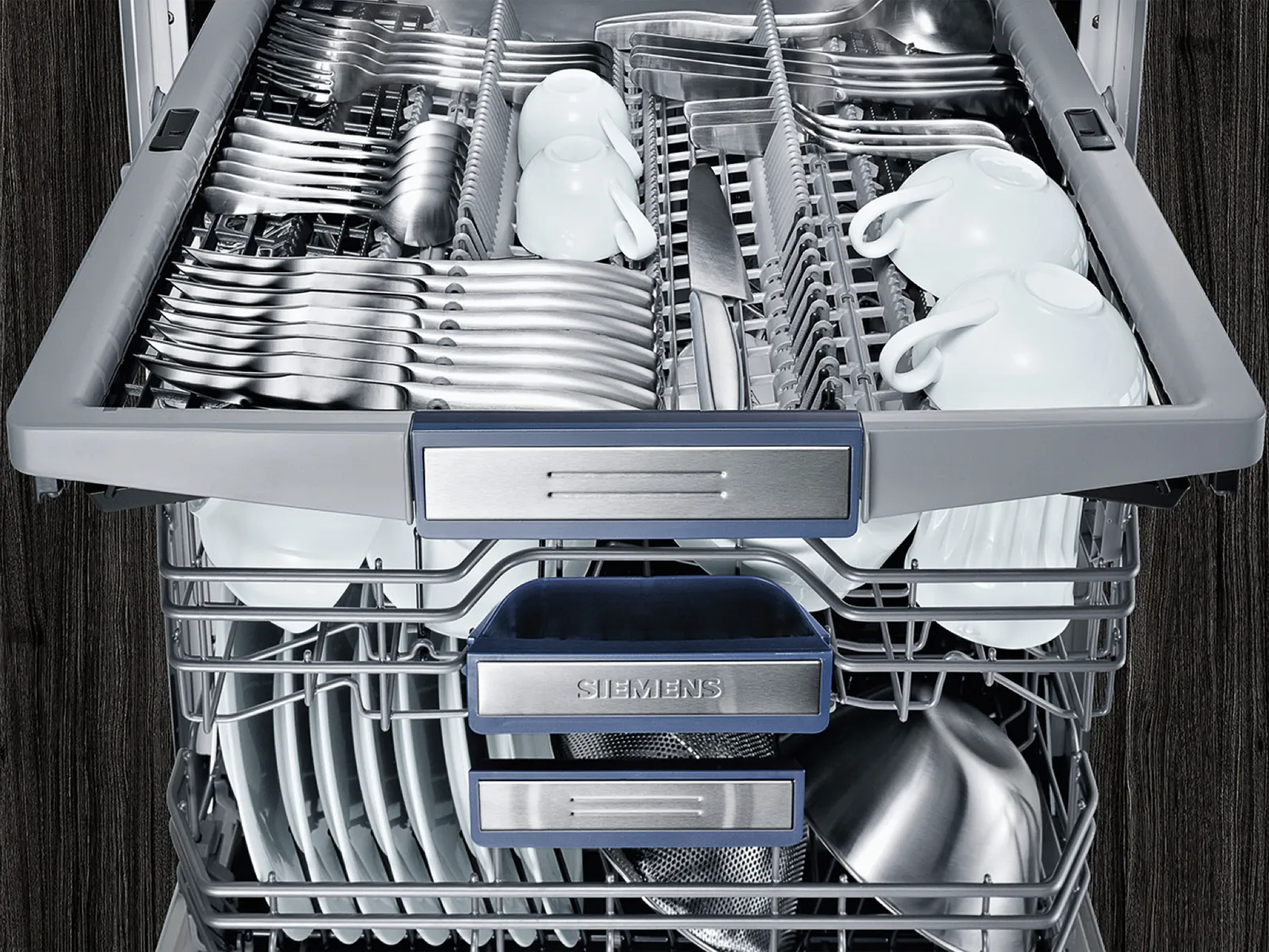 Open dishwasher with clean dishes and visible Siemens logo.