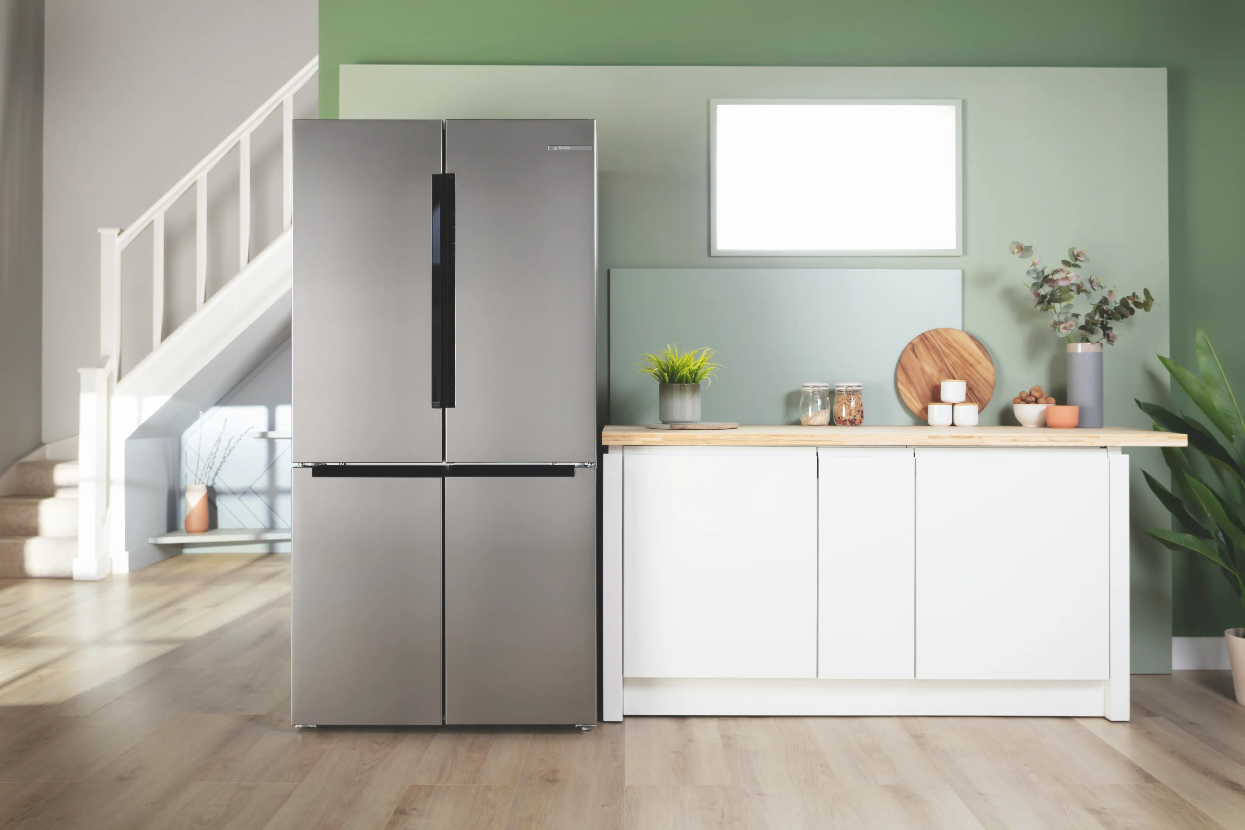 Modern kitchen with black refrigerator, white cabinets, and wooden shelving.