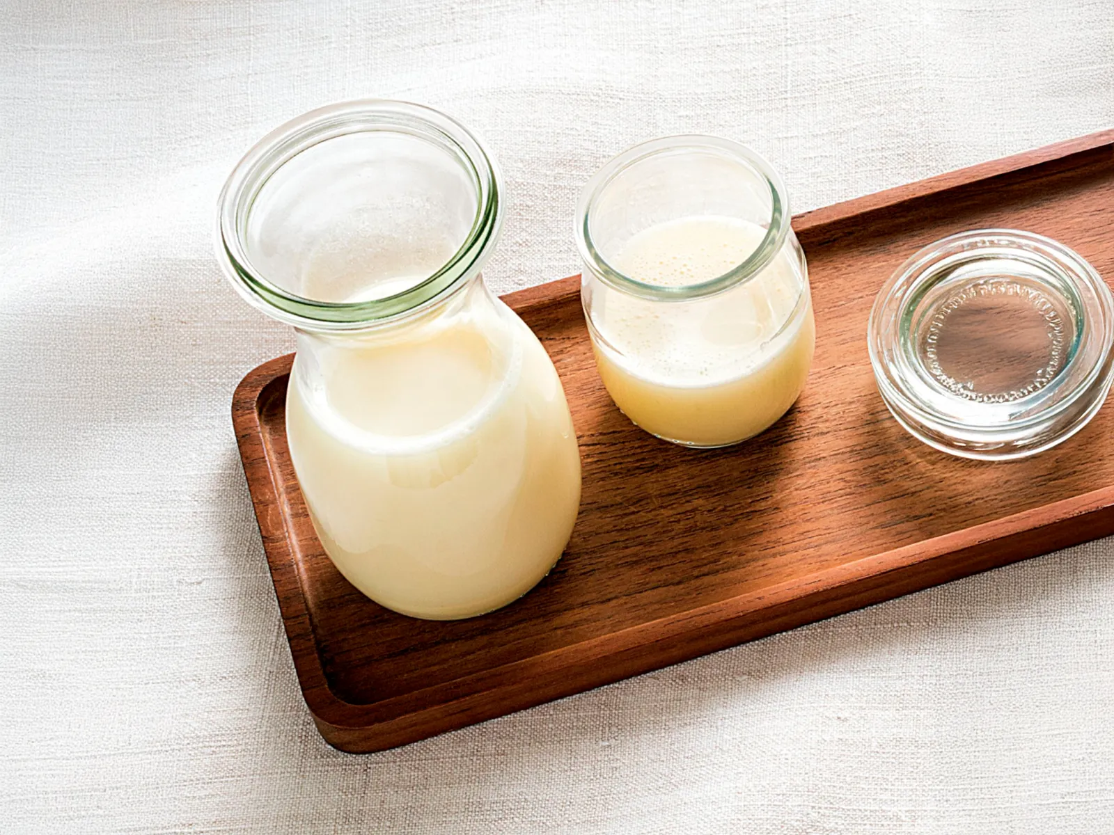 Taxta lövhənin üzərində dayanan soya südü.