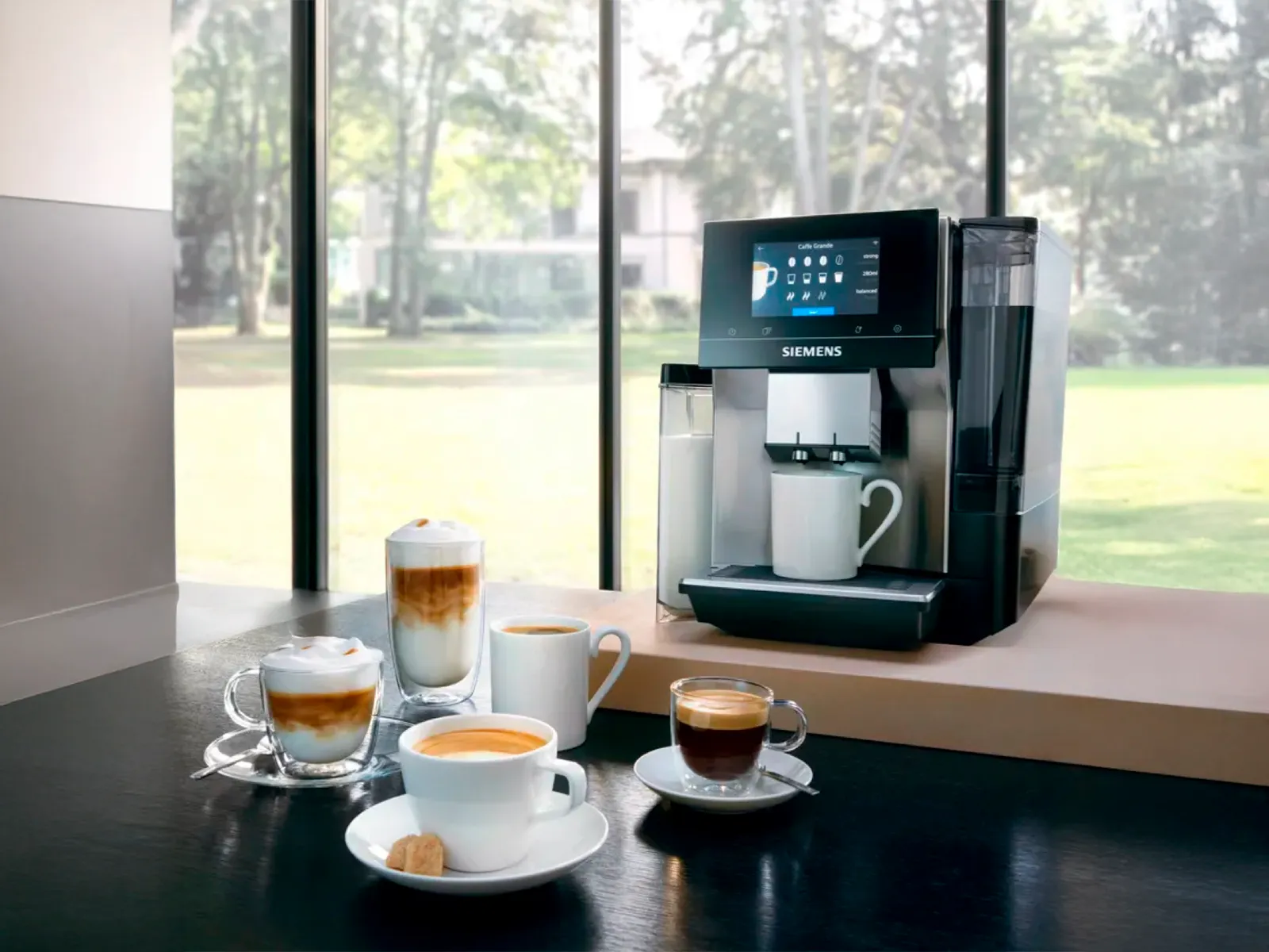 Moderne Siemens kaffemaskine på et bord med forskellige kaffedrikke i et lyst rum.