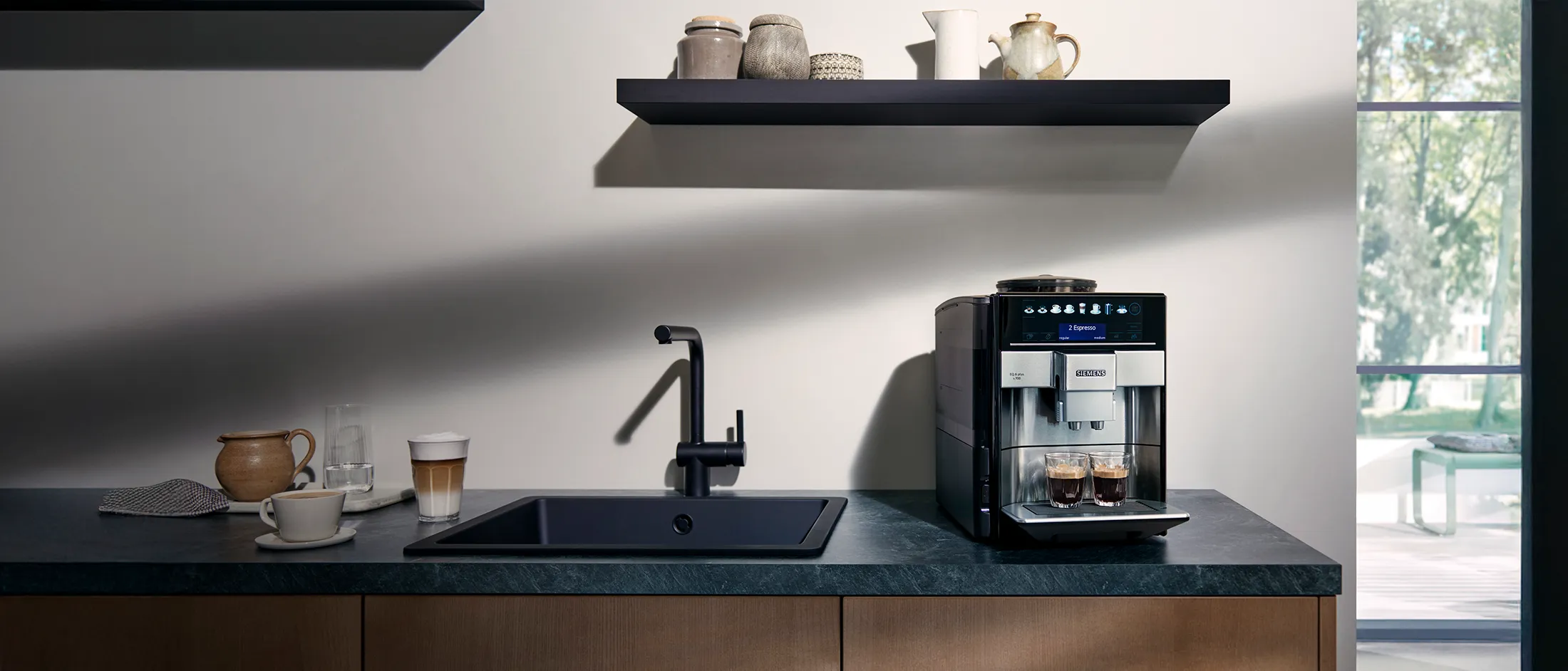 Une machine à café EQ6 plus sur un plan de travail de cuisine dispensant de l'espresso dans deux verres.