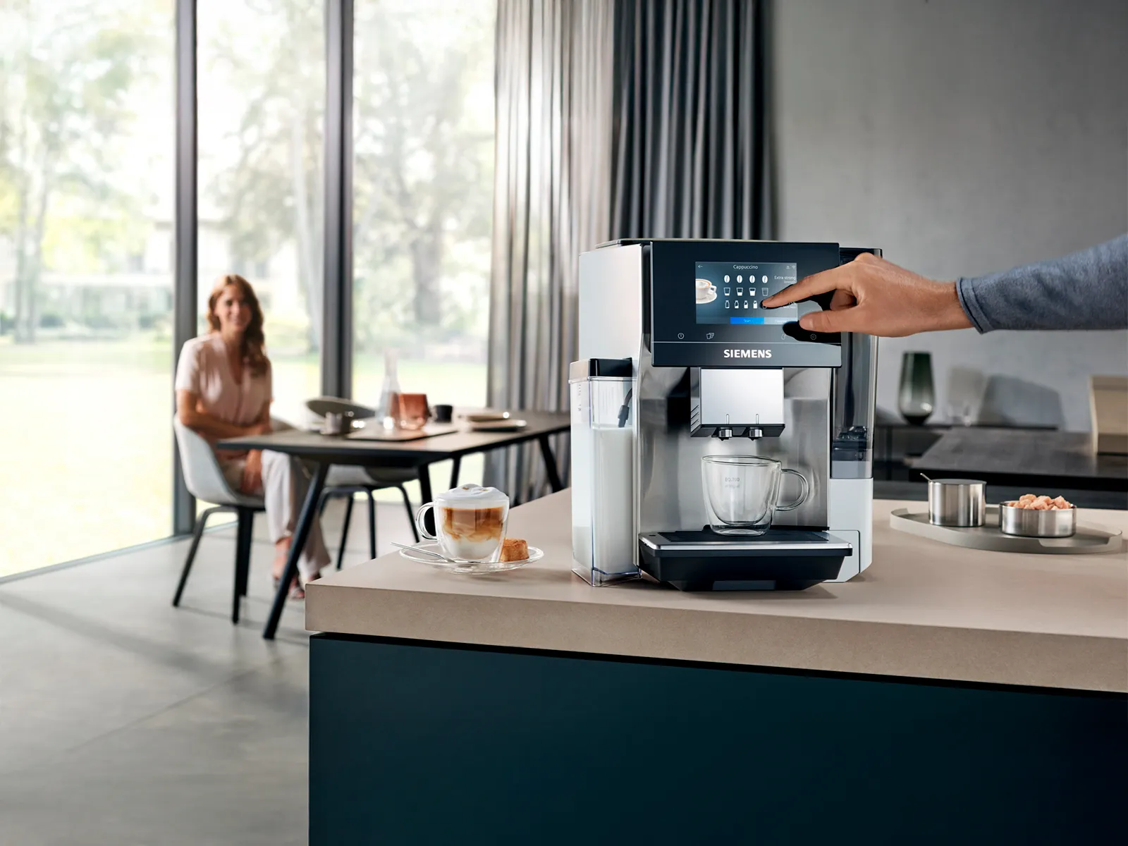 En person betjener en Siemens kaffemaskin på kjøkkenbenken.