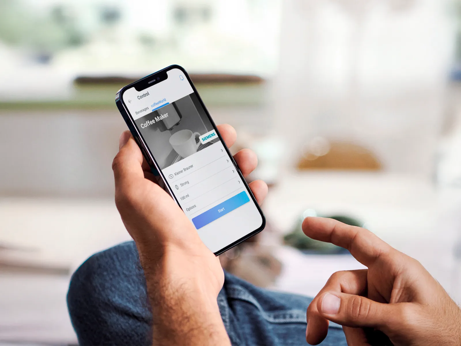 Person, der bruger Siemens Home Connect-appen på en smartphone til at styre en kaffemaskine på afstand.