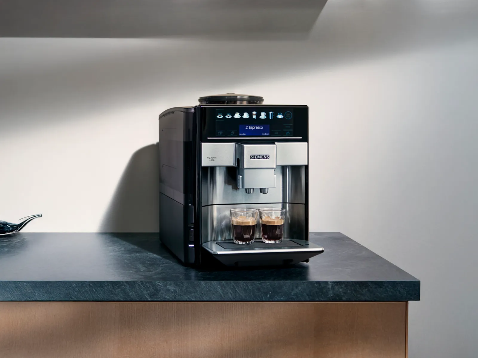 En Siemens EQ6 Plus fuldautomatisk espressomaskine på køkkenbordet forbereder en frisk kop kaffe.