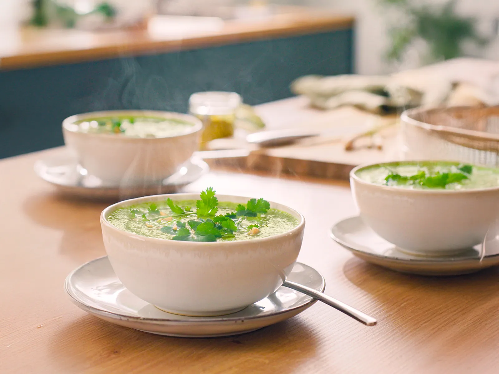 Супа в керамични купи на кухненския плот с гарнитура.